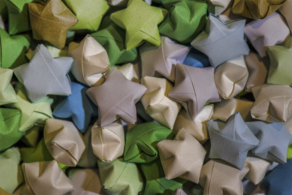 A closeup photograph of many colorful, paper stars sitting in a pile.