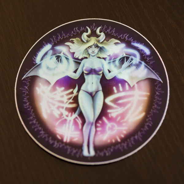 Photograph of the succubus sticker (holographic) available in the Copious Ink Etsy store.